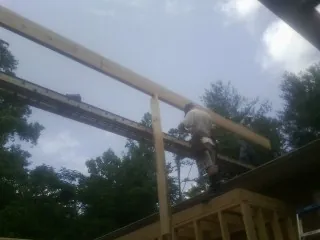 Carpenter setting a ridge beam over a new addition frame — Ice Dam Removal by Roofing Brothers in Los Lunas