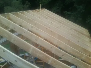New roof rafters set over an addition before sheathing in Los Lunas