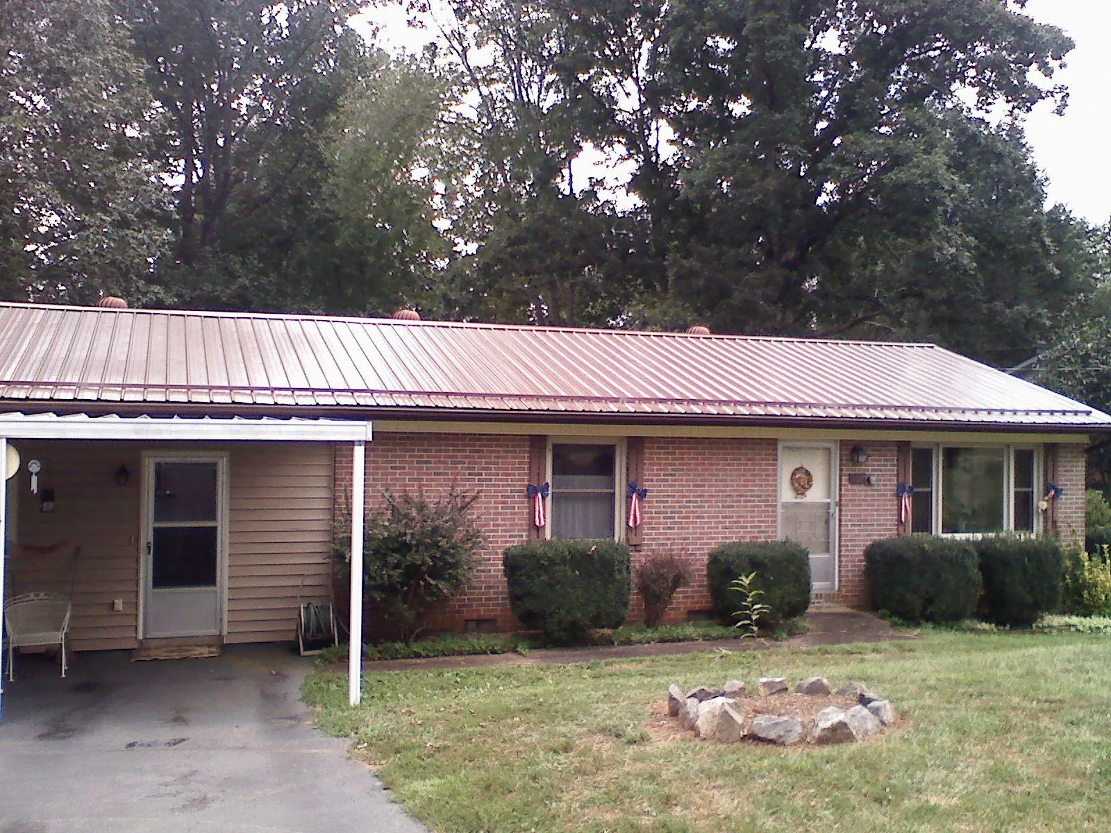 Bronze metal roof and carport on a brick ranch home — Roof Repair work by our crew in Los Lunas